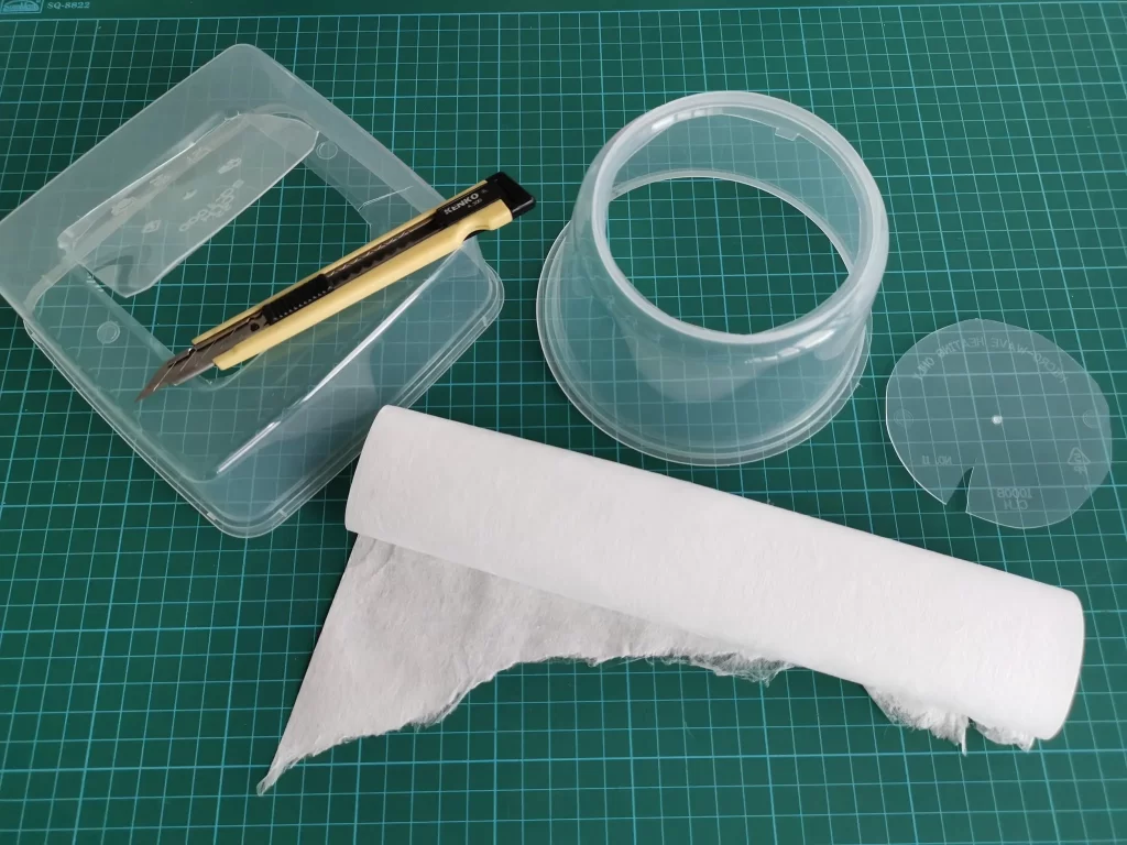 Cut a hole on the bottom of the plastic box. 
(The filter sheet is the white roll near the bottom)